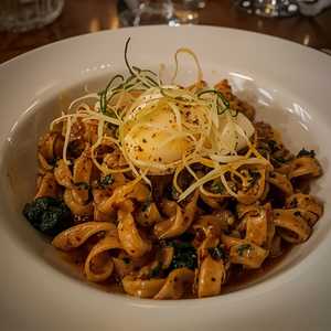 Spätzle de savarin servi avec chicorée grillée, œuf mollet et echalottes croustillantes