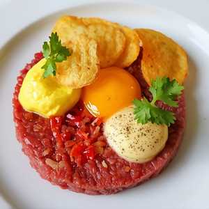 Beef Tartare with Tomato-Red Pepper Purée, Egg Yolk Mousse, and Potato Crisps