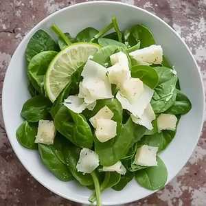 Salade de pousse d'épinard, sauce césar, parmigiano reggiano et citron vert